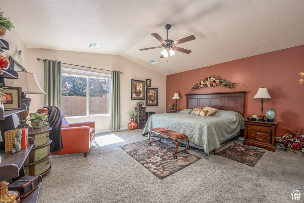 Carpeted bedroom with vaulted ceiling and ceiling fan