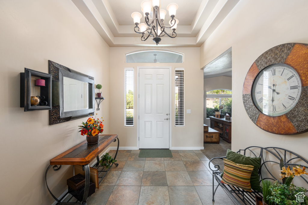 Entrance foyer with a raised ceiling and an inviting chandelier