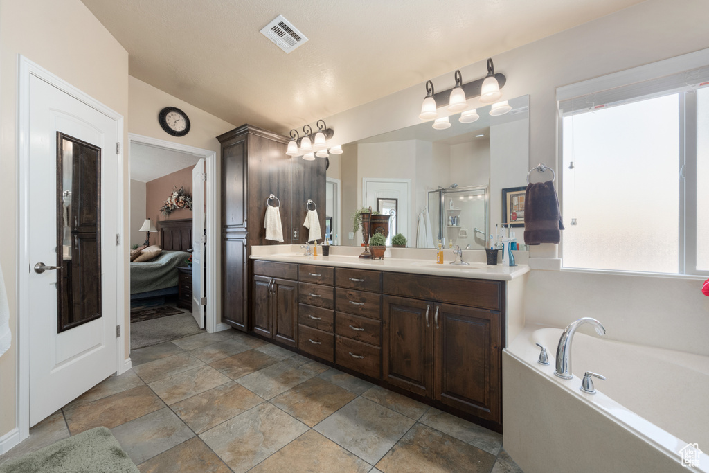 Bathroom featuring independent shower and bath and vanity