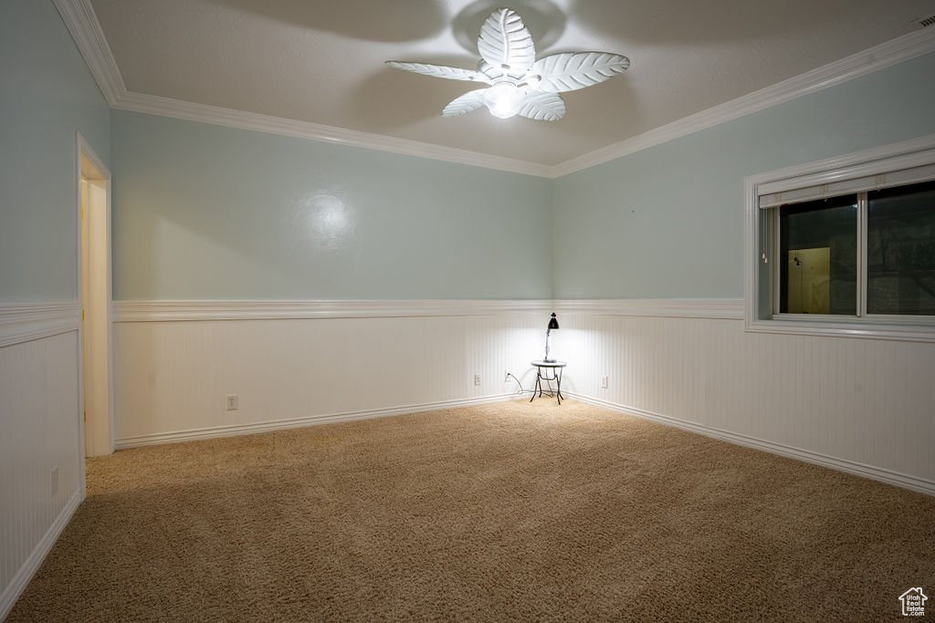 Carpeted spare room with ornamental molding and ceiling fan