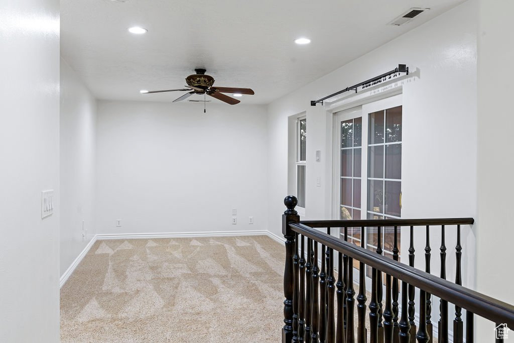 Carpeted spare room with ceiling fan