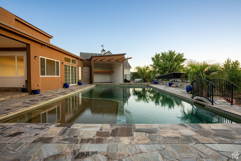 Pool at dusk with a patio