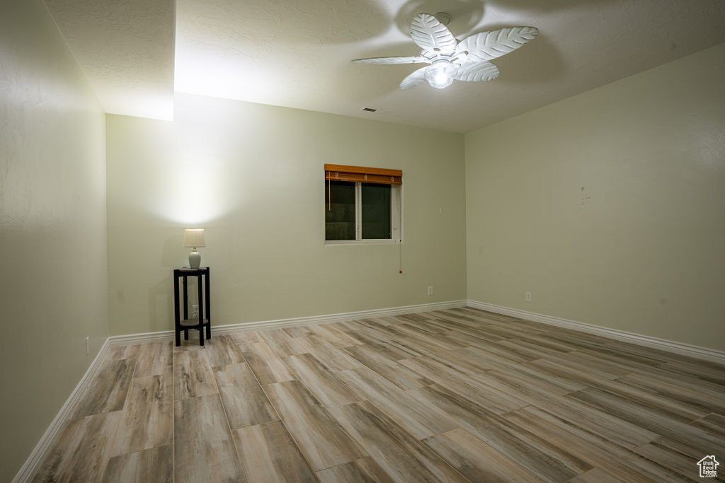 Unfurnished room featuring ceiling fan and light hardwood / wood-style flooring