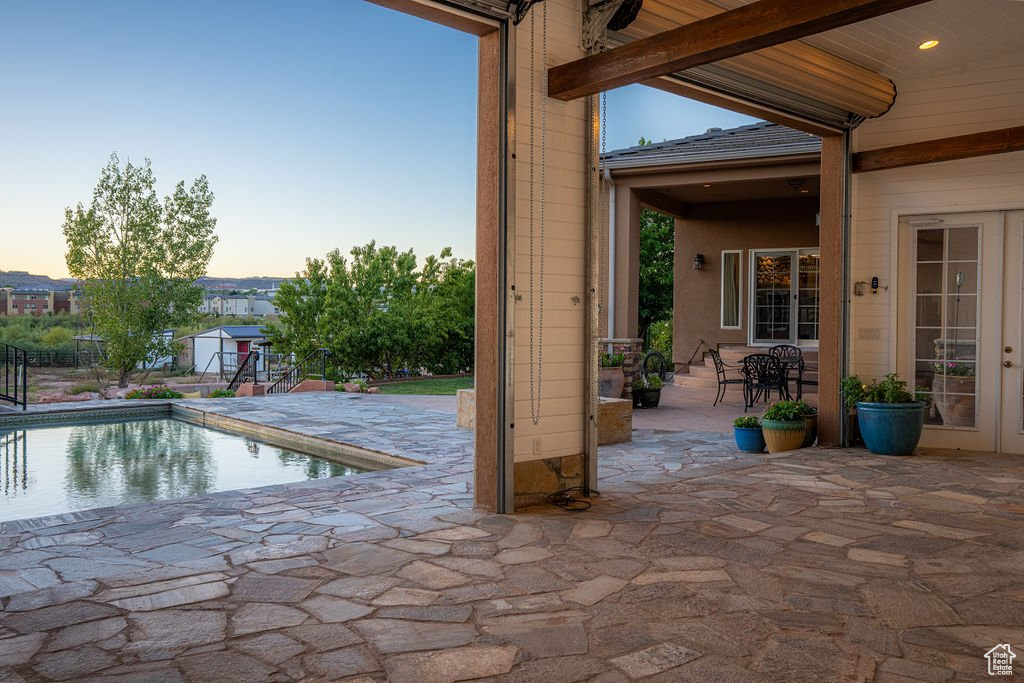 Pool at dusk featuring a patio area