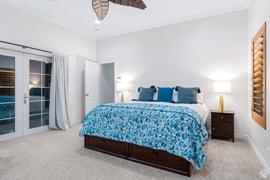 Carpeted bedroom with crown molding, french doors, and access to exterior