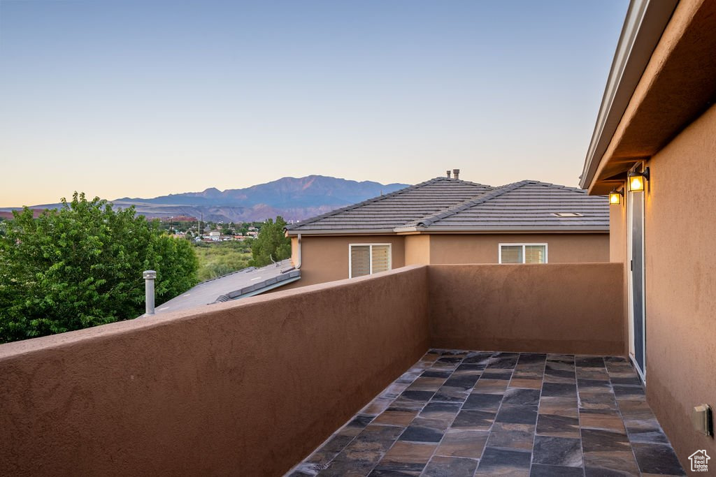 Balcony at dusk featuring a mountain view