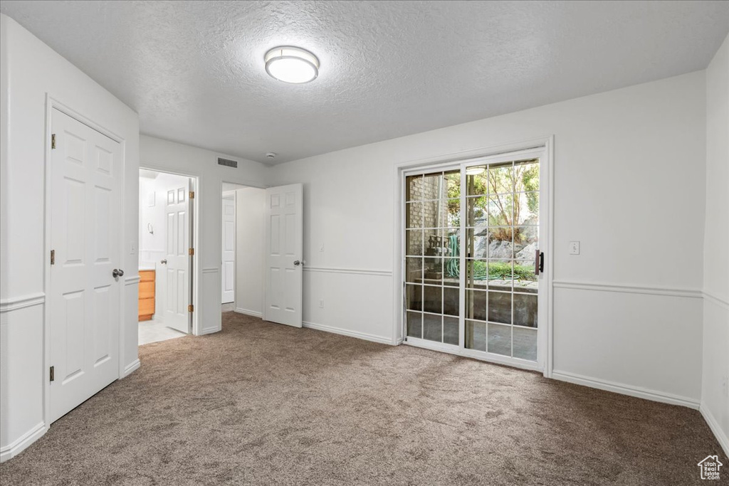 Carpeted empty room with a textured ceiling