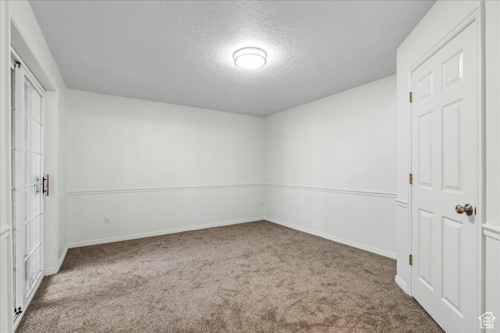 Unfurnished bedroom featuring a closet, a textured ceiling, and carpet flooring