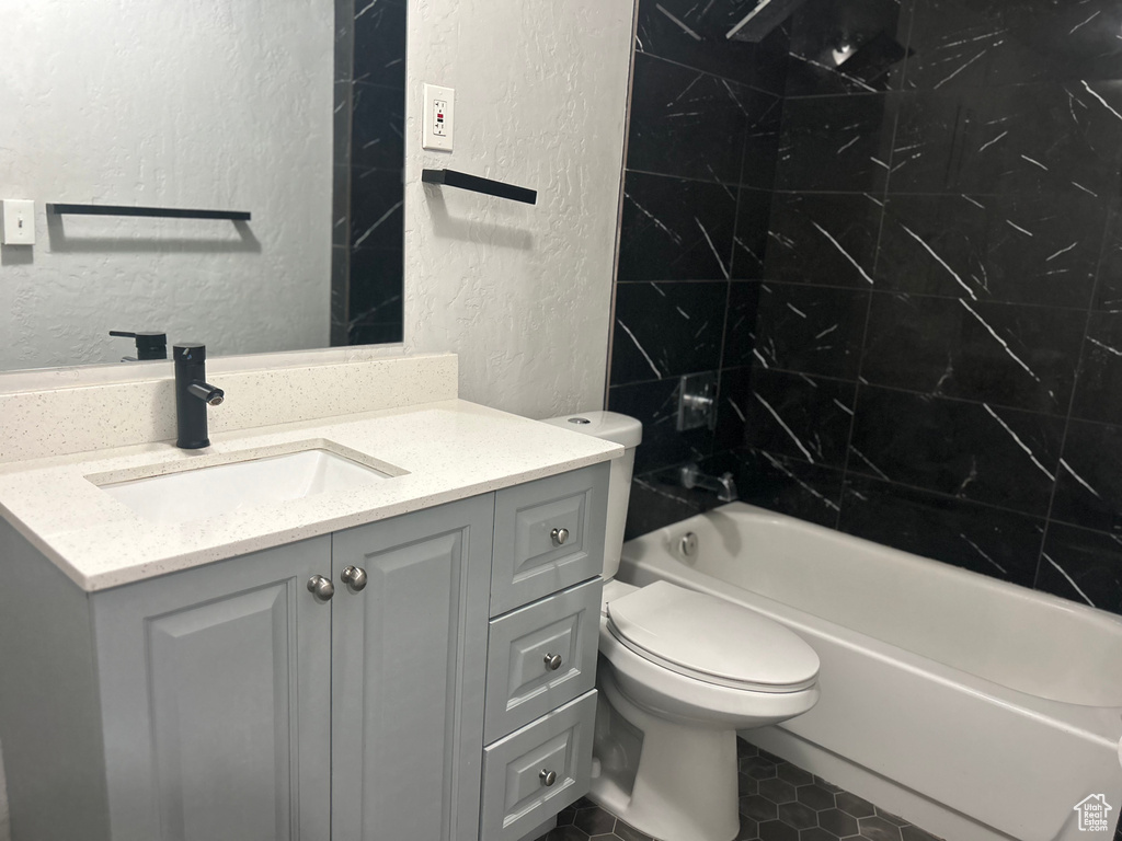 Full bathroom with tiled shower / bath, vanity, toilet, and tile patterned floors