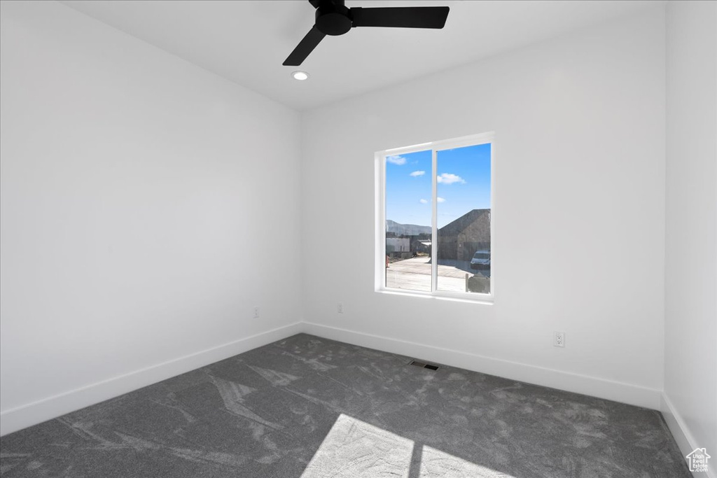 Carpeted empty room featuring ceiling fan