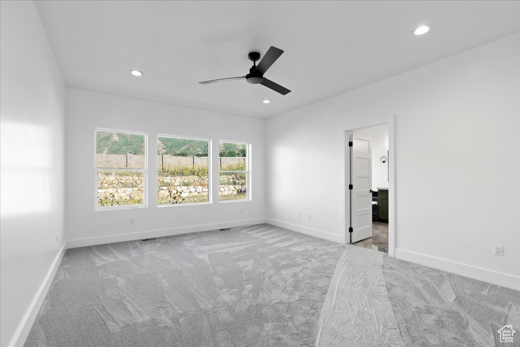 Unfurnished bedroom with ceiling fan and light colored carpet