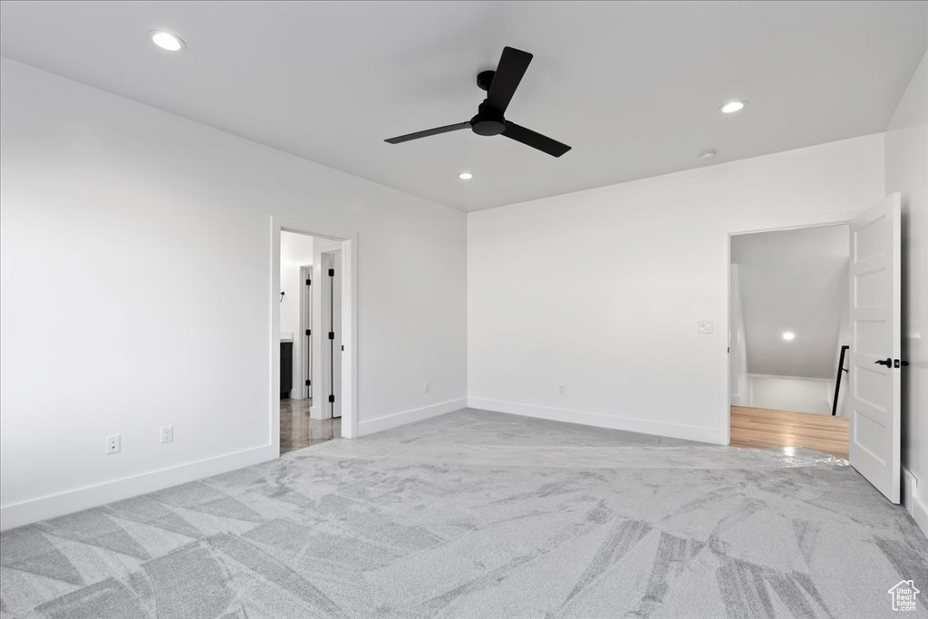 Unfurnished bedroom with ceiling fan and light colored carpet