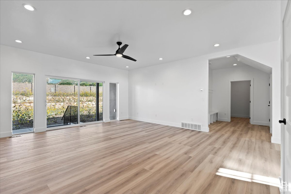 Unfurnished living room featuring ceiling fan and light hardwood / wood-style flooring