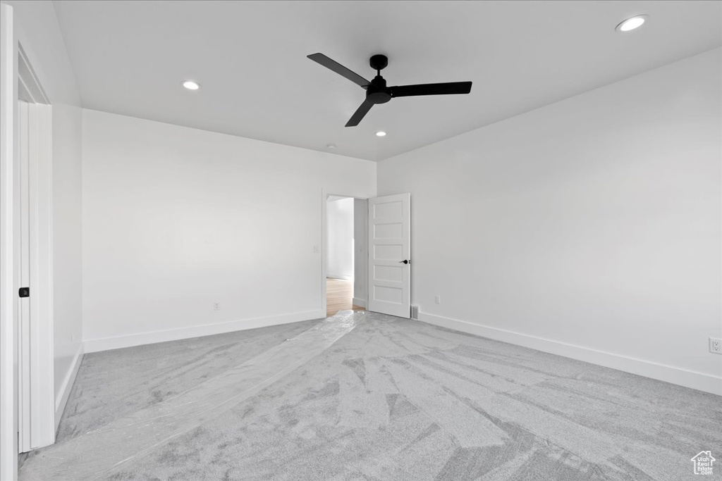 Carpeted empty room featuring ceiling fan