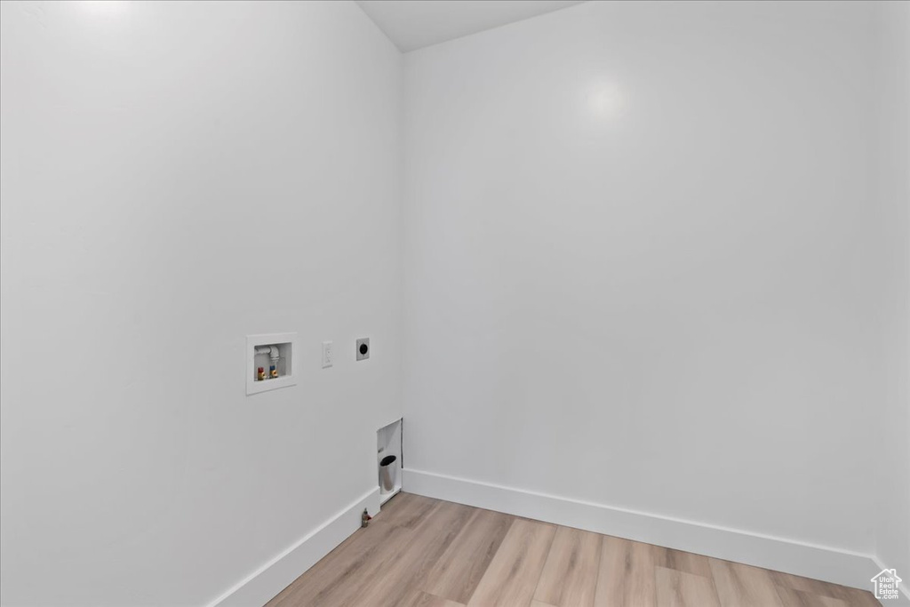 Clothes washing area featuring washer hookup, light wood-type flooring, and hookup for an electric dryer