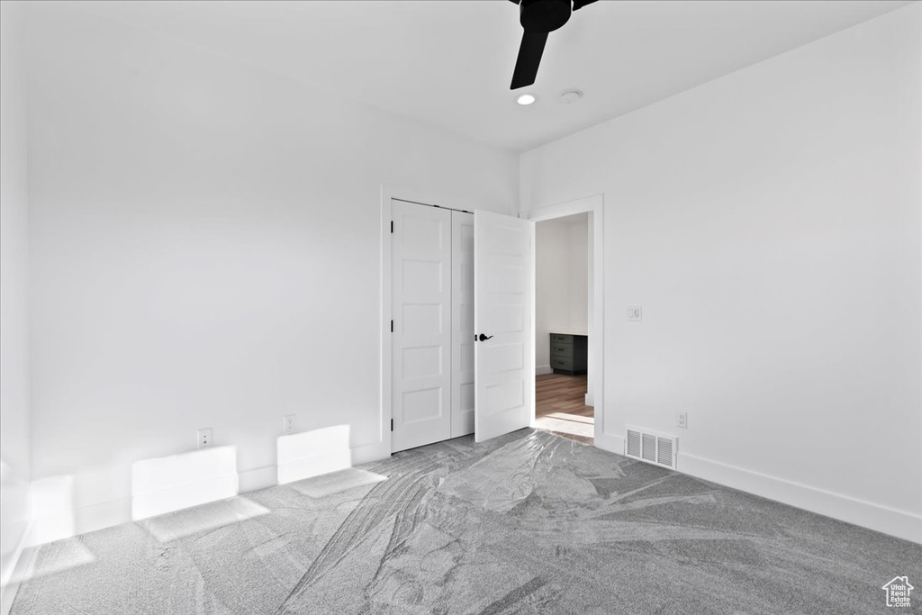 Carpeted spare room with ceiling fan