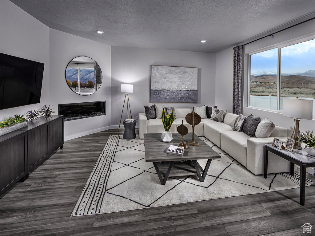 Living room with a textured ceiling, a mountain view, and hardwood / wood-style flooring