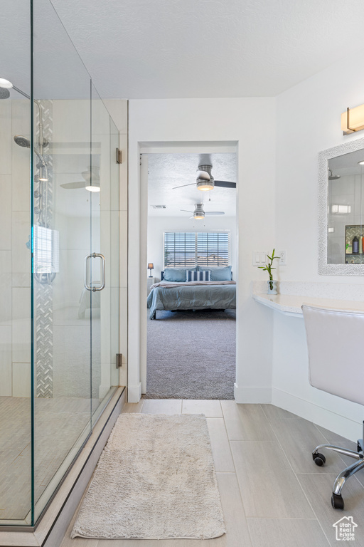 Bathroom with tile patterned flooring, ceiling fan, and walk in shower