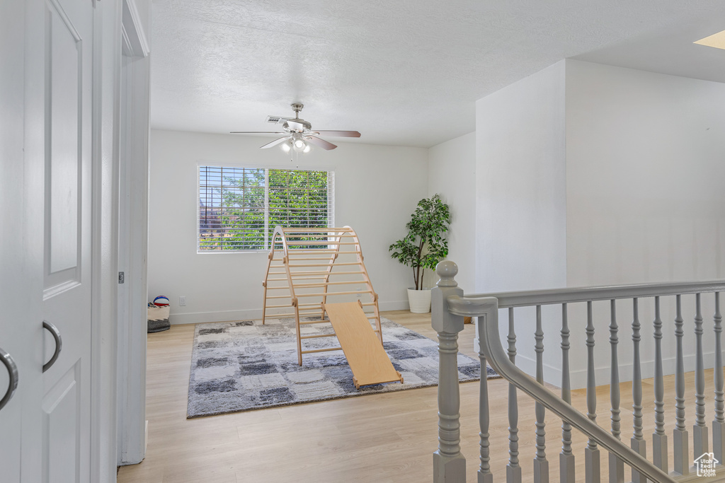 Interior space with a textured ceiling and light hardwood / wood-style floors