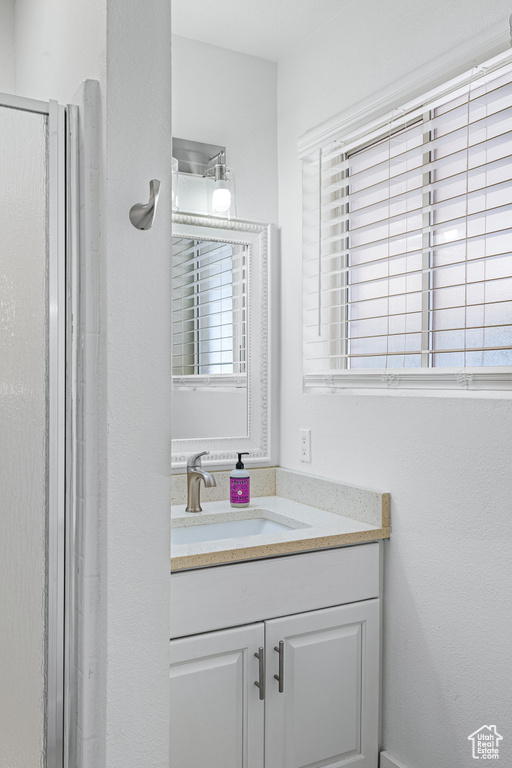 Bathroom with vanity and a shower with shower door