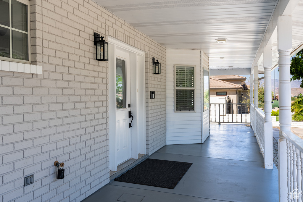 Doorway to property featuring covered porch