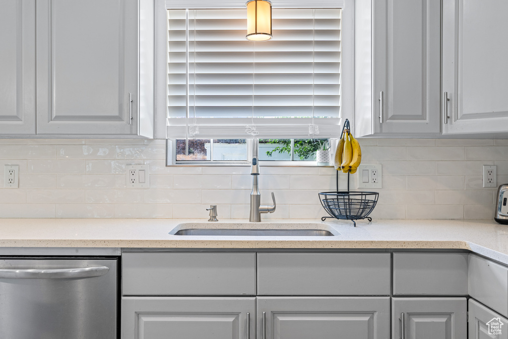 Kitchen featuring backsplash, sink, and stainless steel dishwasher