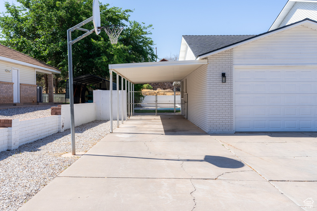 View of side of home featuring a garage and a carport