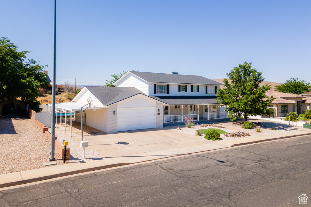 View of front of property featuring covered porch and a garage