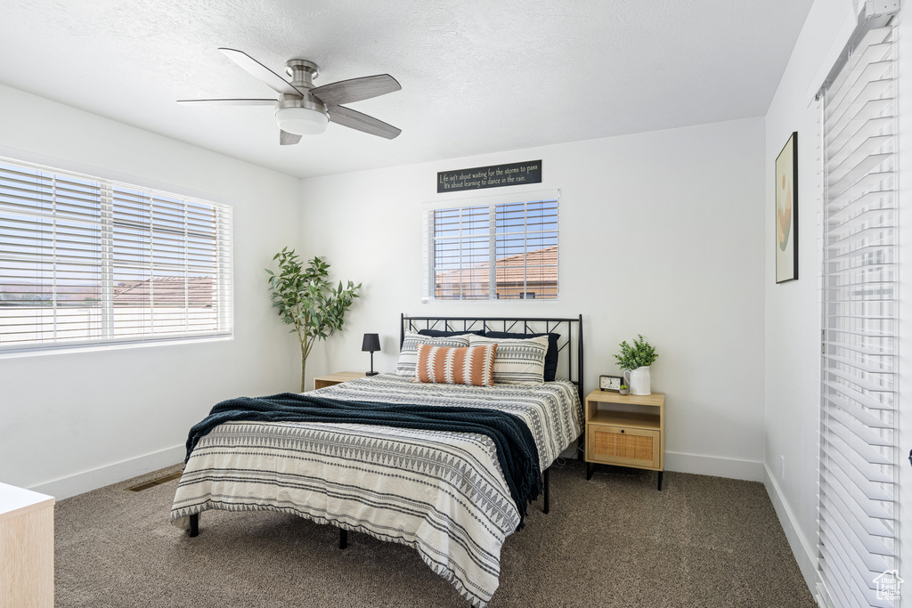 Carpeted bedroom with a textured ceiling and ceiling fan