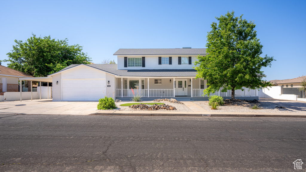 View of front of property featuring covered porch and a garage