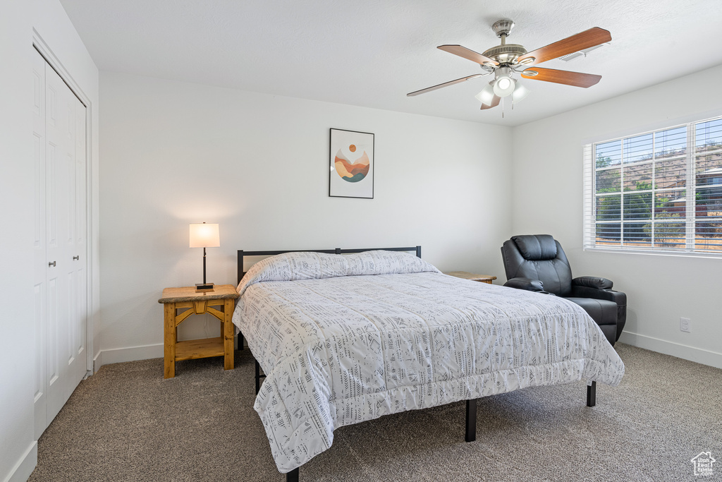 Bedroom featuring carpet, ceiling fan, and a closet