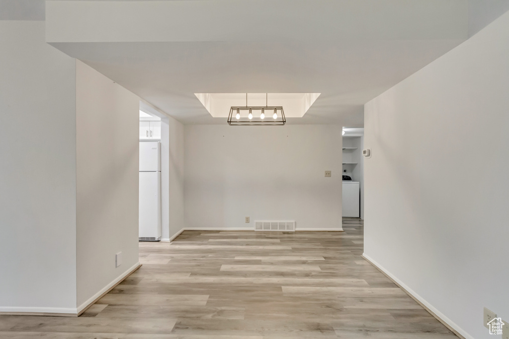 Unfurnished dining area with washer / clothes dryer and light hardwood / wood-style flooring