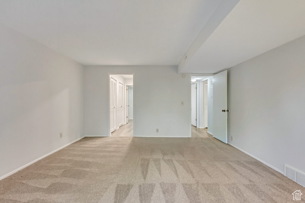 Unfurnished room featuring light carpet