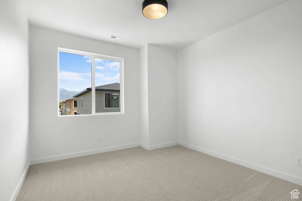 Unfurnished room featuring light colored carpet