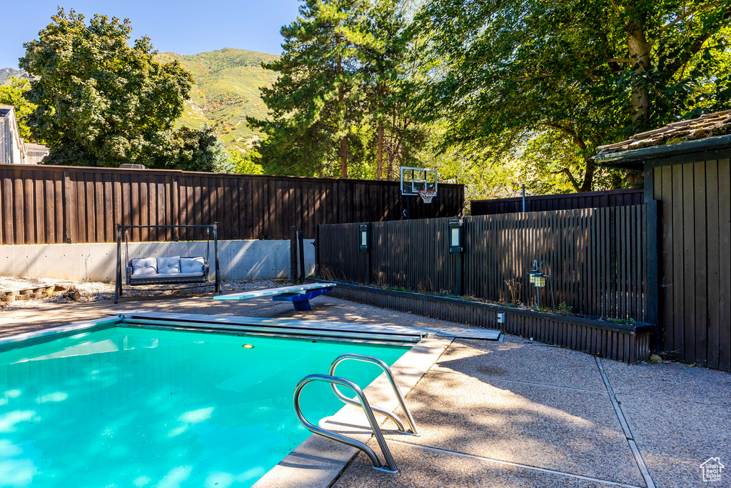 View of swimming pool with a mountain view and a patio