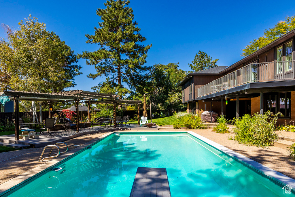 View of pool featuring a diving board and a patio area