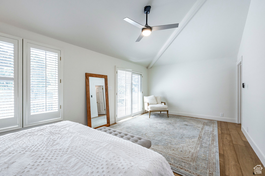 Bedroom with ceiling fan, hardwood / wood-style flooring, vaulted ceiling, and multiple windows