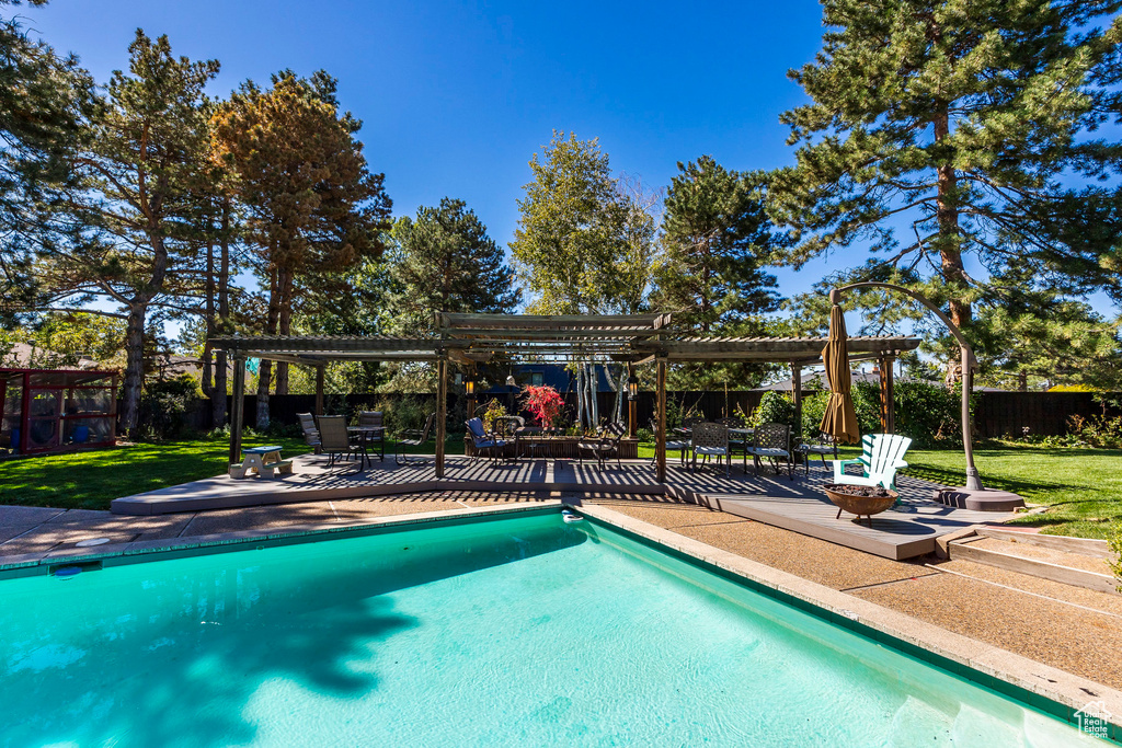 View of swimming pool featuring a lawn, a pergola, a patio, and an outdoor fire pit