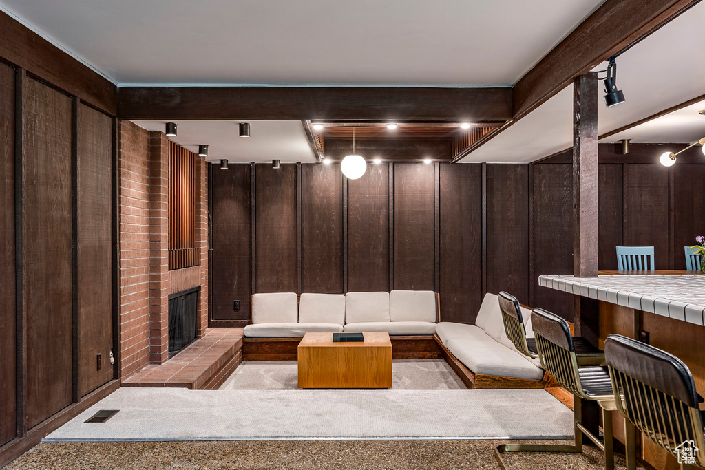 Interior space featuring beamed ceiling, a fireplace, and wood walls