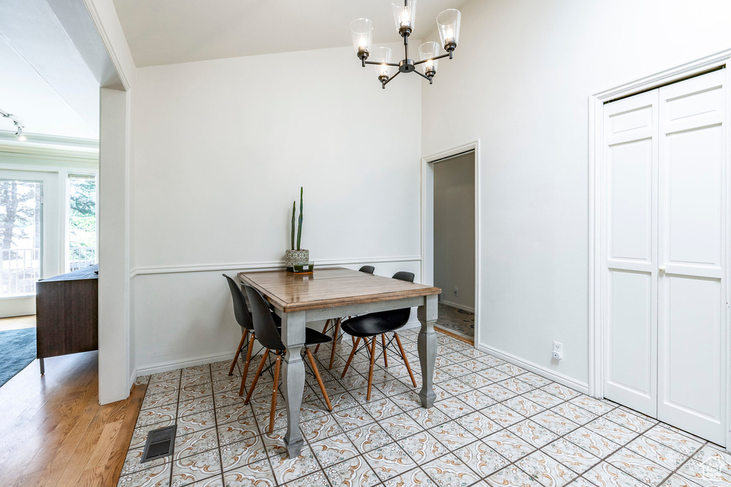 Dining room featuring light wood-type flooring and a notable chandelier