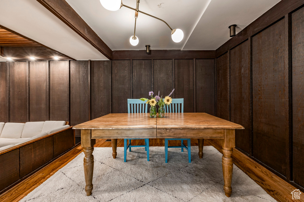 Unfurnished dining area with light hardwood / wood-style flooring and wood walls