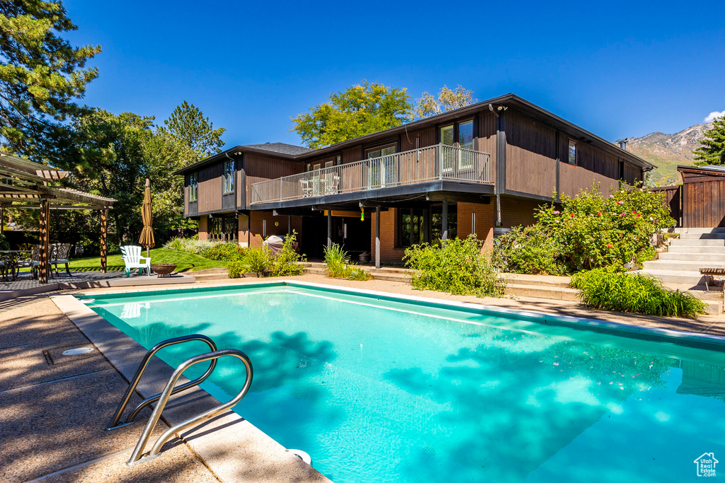 View of pool with a mountain view and a patio area