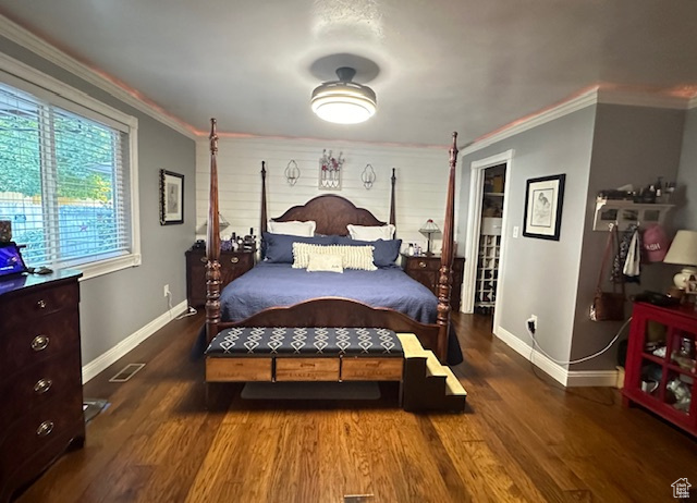 Bedroom with dark hardwood / wood-style floors and crown molding