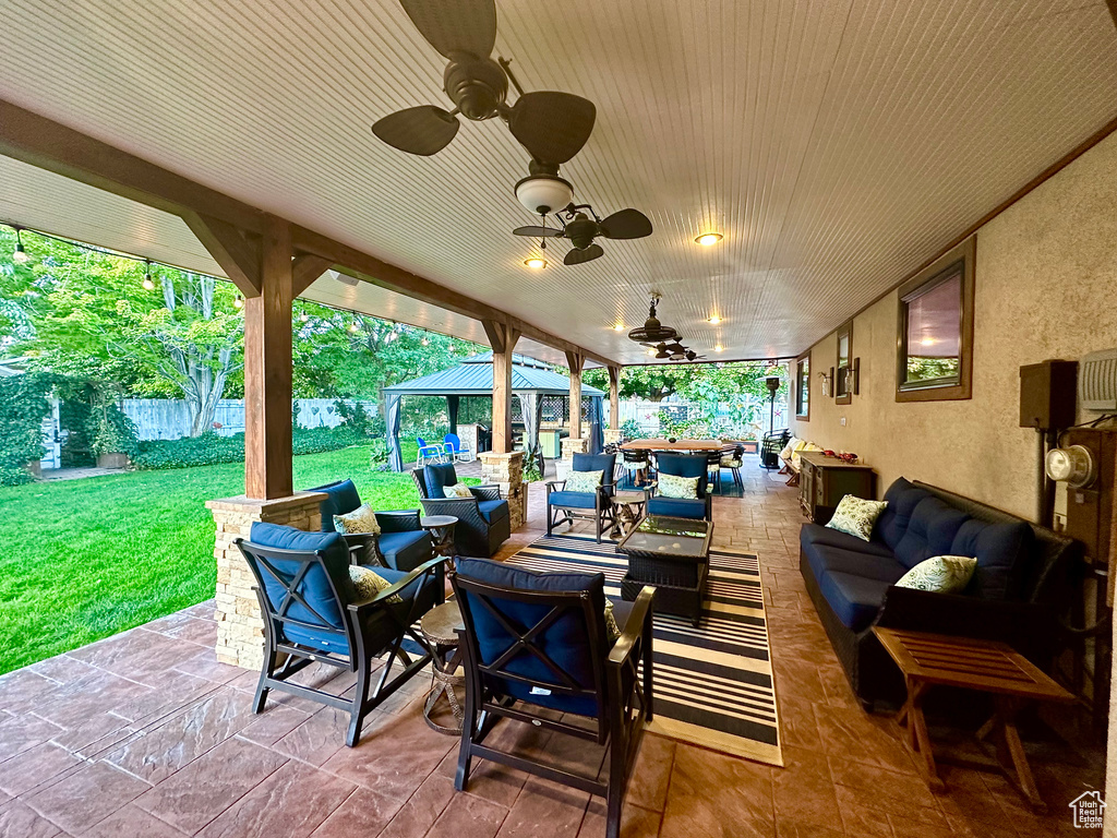 View of patio with an outdoor living space, a gazebo, and ceiling fan