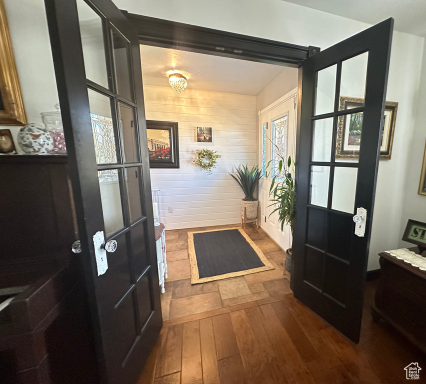 Entrance foyer featuring wood-type flooring and wood walls