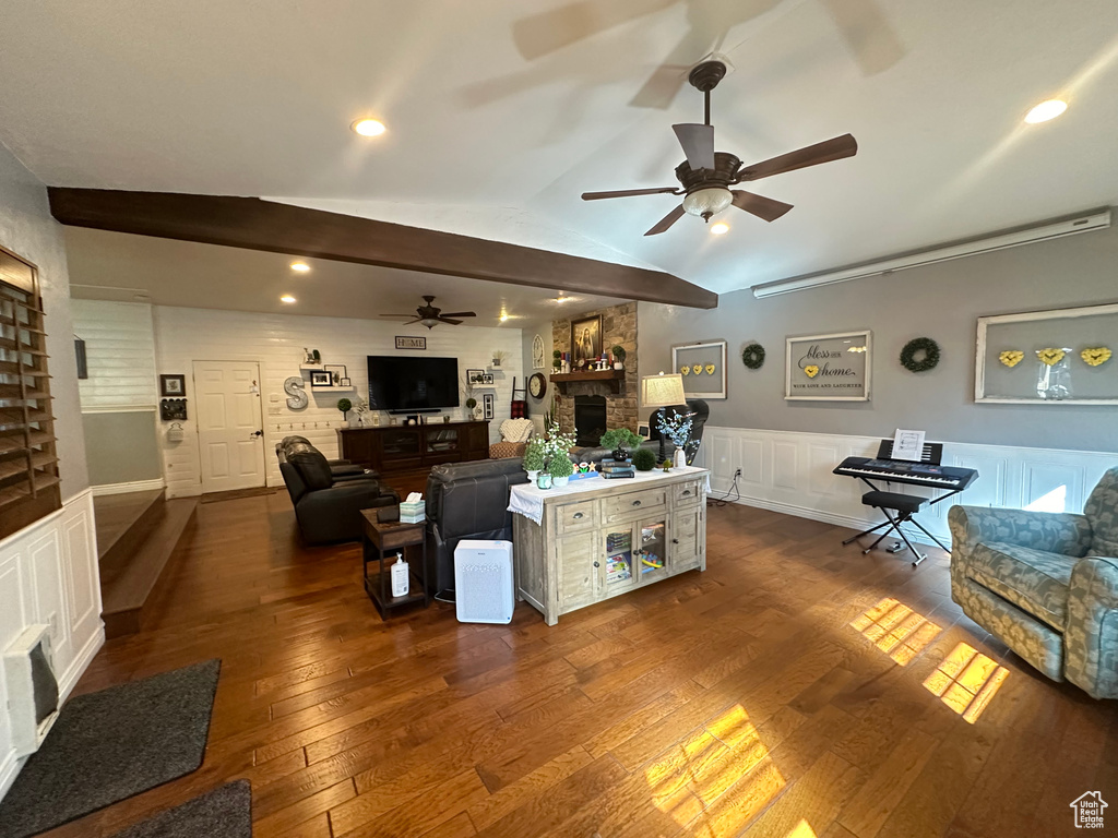 Living room featuring ceiling fan, lofted ceiling, and dark wood-type flooring