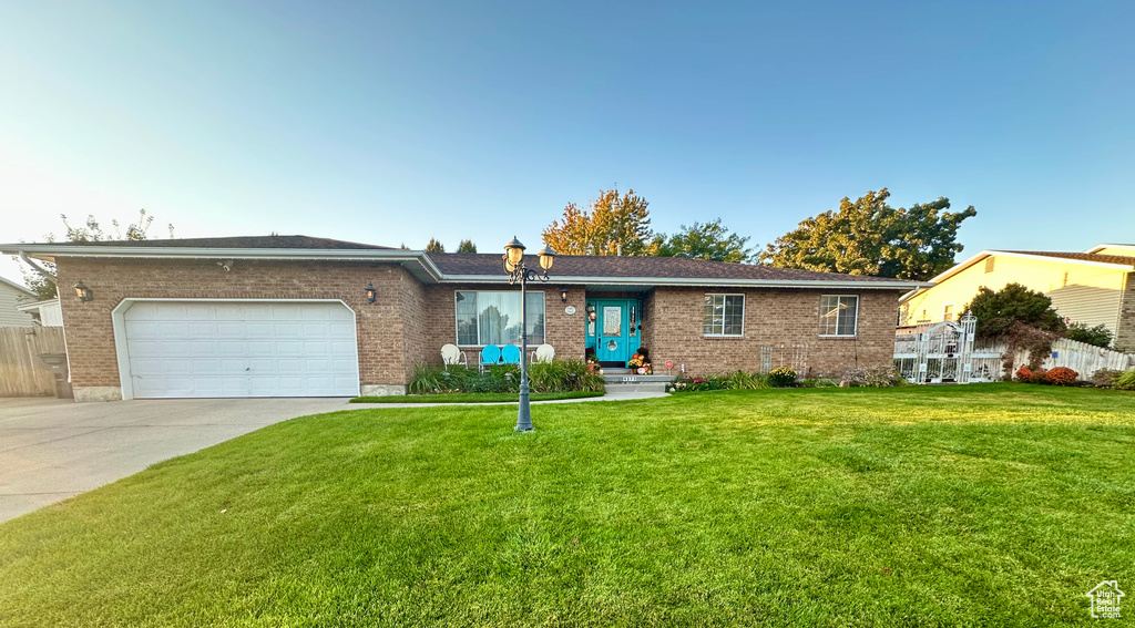 Ranch-style home with a front lawn and a garage