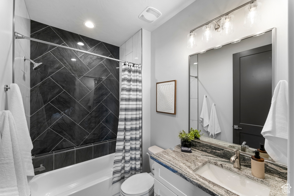 Full bathroom with vanity, toilet, and shower / bath combo with shower curtain