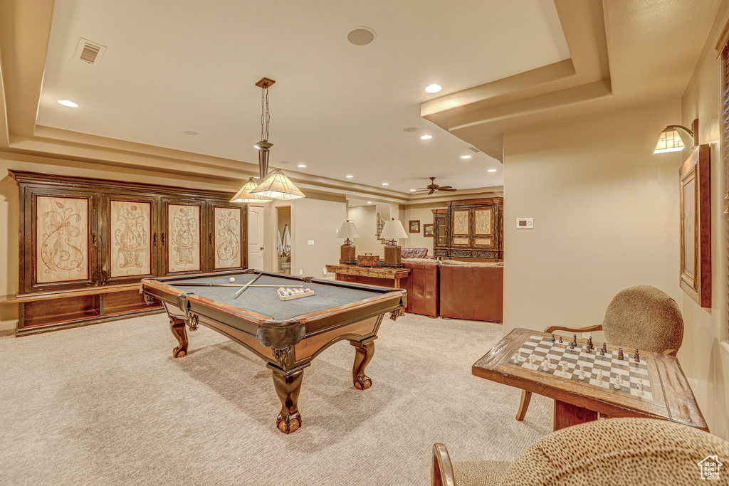 Game room with bar, a tray ceiling, light carpet, and billiards