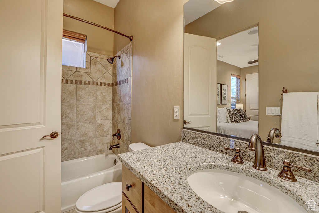 Full bathroom featuring vanity, toilet, and tiled shower / bath